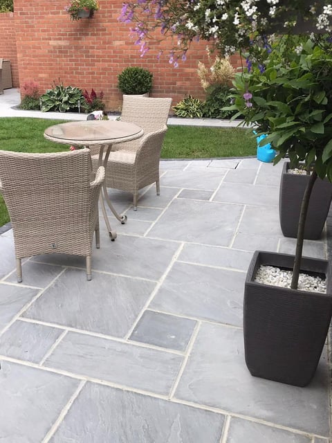 Outdoor patio with gray stone pavers, rattan furniture