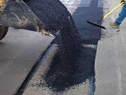 Asphalt being applied to concrete road surface during construction or resurfacing work