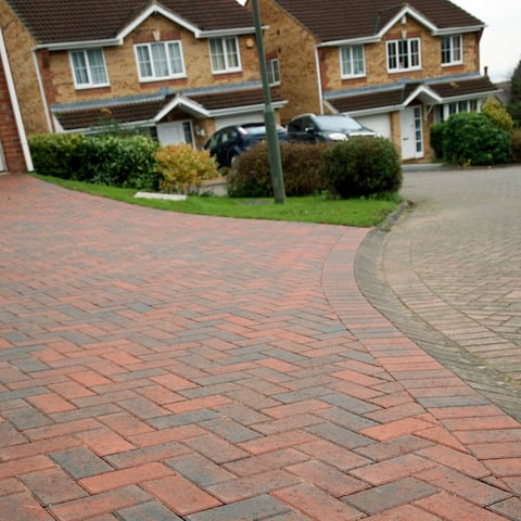 Two brick townhouses with curved brick paved driveway