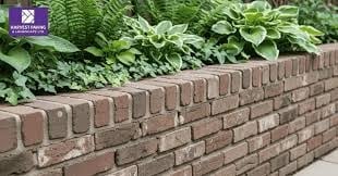 Brick garden wall with lush green plants